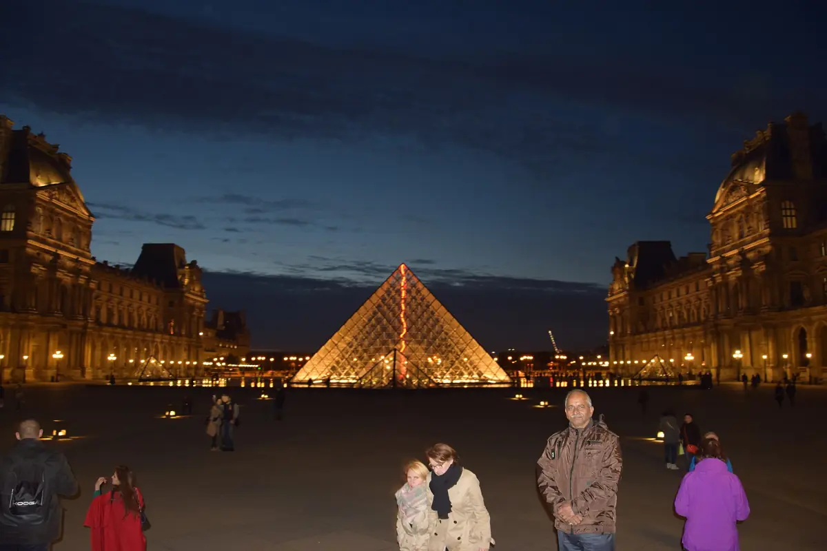 Besucher im Hof des Louvre am Abend